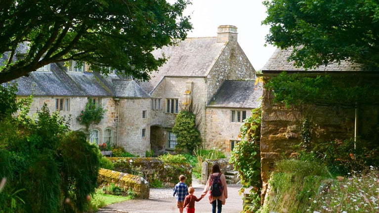A family walking through Trerice in summer, with the rear court in background, Trerice, Cornwall